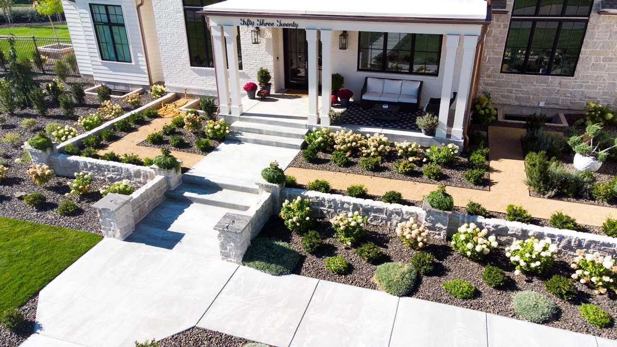Aerial view of a completed B&K landscape with paver patio, lawn, and planting beds